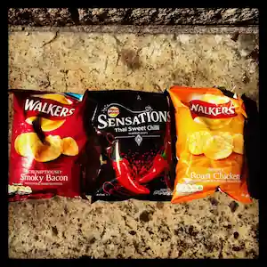 Three bags of Walkers Crisps potato chips with three different flavors: Smoky Bacon, Thai Sweet Chili, and Roast Chicken