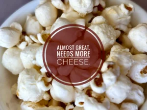 A close up of Simply Smartfood popcorn with the text "Almost Great. Needs more cheese."